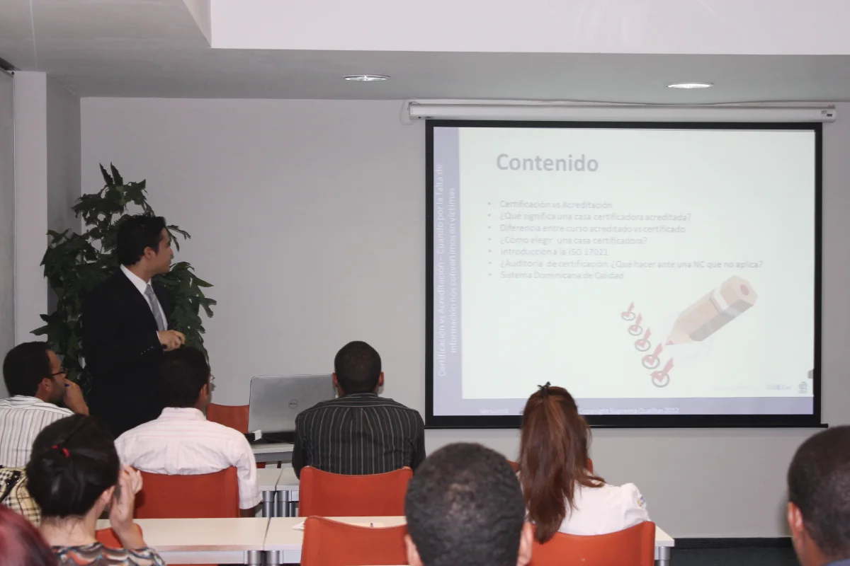 Instructor de Suprema Qualitas en un salón impartiendo una charla a los participantes.